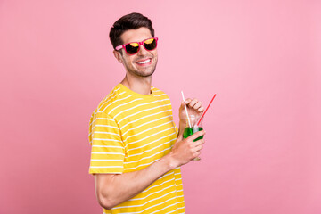 Profile side view portrait of attractive cheerful guy drinking beverage having fun chill isolated over pink pastel color background