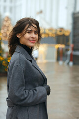 Fototapeta premium Cheerful woman walking at the city decorated to New Year