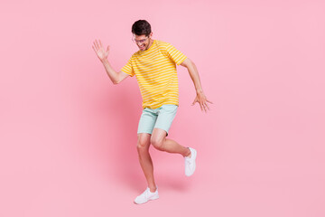Full size photo of positive young happy man wear glasses smile dance isolated on pastel pink color background