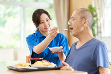 Fototapeta na wymiar 高齢者に食事の介助をする介護士