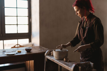 Young woman sculptor artist creating a bust sculpture