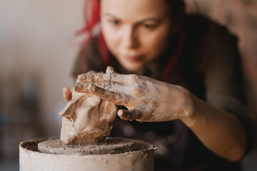 Young woman sculptor artist creating a bust sculpture - obrazy, fototapety, plakaty