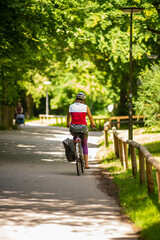Fototapeta premium Woman riding a bicyle in summer in a bike path