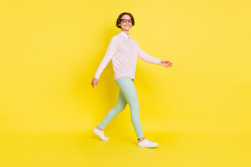 Fototapeta na wymiar Full length body size photo of cheerful model going forward in casual clothes isolated vivid yellow color background