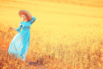 Girl in a long vintage dress hat in a field of flowers, happy summer sunny freedom female