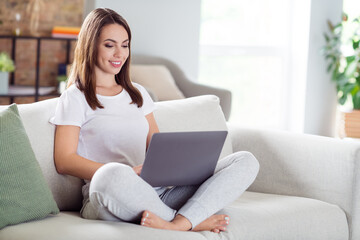 Photo portrait brunette woman sitting on couch at home working on laptop wremotely while quarantine