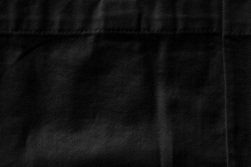 Wrinkled black textile texture with seams background