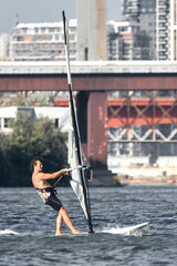 Windsurfer surfing on a windy day at the city river.