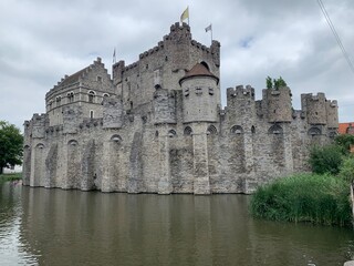 Fototapeta premium Facade of the Gravensteen medieval ages castle surrounded by water canal. Ghent, East Flanders, Belgium.