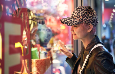 portrait of Asian beauty smiling and looking into store window when Christmas shopping