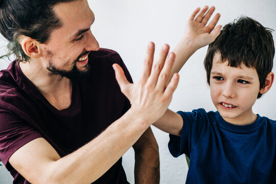Professional psychologist tutor man cheerfully plays with an autism child during therapy. Autism, asperger child lifestyle concept
