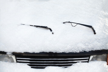Car wipers and windscreen covered with snow
