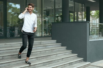 Businessman go on stairs and talk on mobile phone