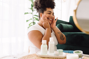 Smiling woman doing skin care at home - obrazy, fototapety, plakaty