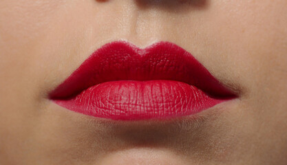 Lips with vivid intense saturated red lipstick extreme close-up. Big puffy lips of a caucasian...