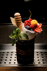 Gorgeous ceramic glass with ice decorated with mint and berries and honey dipper