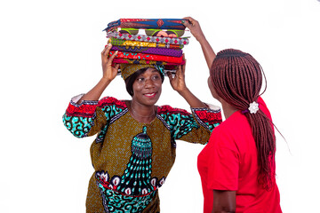 beautiful woman showing different traditional loincloths on the head to a client, smiling.