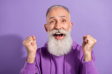Portrait of attractive lucky cheerful grey-haired man celebrating great success isolated over purple violet color background
