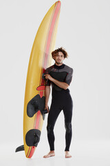 Young european curly surfer stand with surfboard - obrazy, fototapety, plakaty