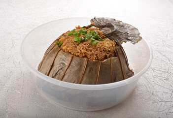 glutinous sticky fried rice with meat wrapped in lotus leaf in party bento tray box for asian take away halal menu