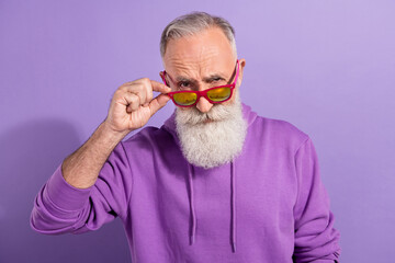 Portrait of attractive cool funky hipster grey-haired man touching modern specs isolated over purple violet color background