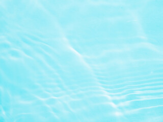 Ripple water texture on blue pool background. Shadow of water on sunlight. Mockup for product, spa or travel background. Marble blue water surface as wallpaper background