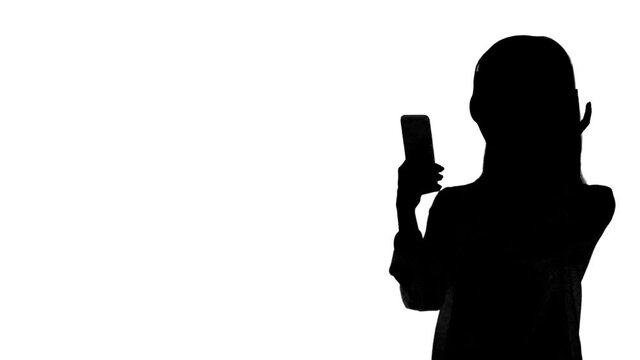 スマホで音楽を聴く女性のシルエット