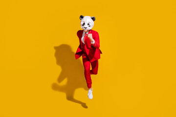 Photo of incognito panda guy jump run fast wear mask red tuxedo footwear isolated on yellow color background