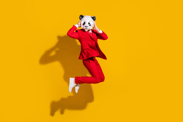 Photo of sportive crazy panda guy jump enjoy flight wear mask red tux shoes isolated on yellow...