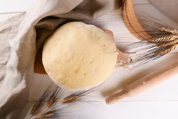 Raw homemande dough for bread or pizza with ears of wheat