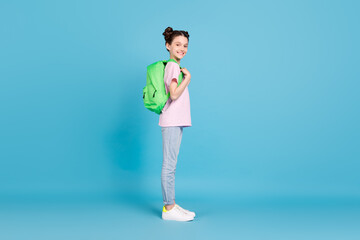 Fototapeta na wymiar Full body profile side photo of happy little girl wear backpack student isolated on pastel blue color background