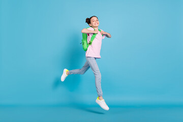 Fototapeta na wymiar Full length photo of cheerful young happy girl jump up wear backpack walk isolated on blue color background