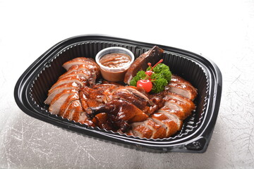 roasted bbq Peking duck crispy skin with sweet sauce in black party bento tray box for asian take away halal menu