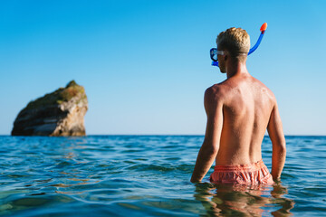 Happy man with mask for snorkling at the seaside beach on summer vacation