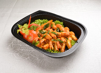 stir fried big tiger prawn with pumpkin creamy sauce and curry leaf in black party bento tray box for asian take away halal menu
