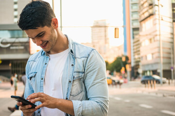 Young caucasian man smiling with a smart phone. Back to work.