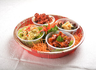 cold combo salad platter with sweet and sour pork, stir fried scrambler egg, preserved century egg with ginger and Japanese red marinated octopus in round party bento tray box for asian take away hala