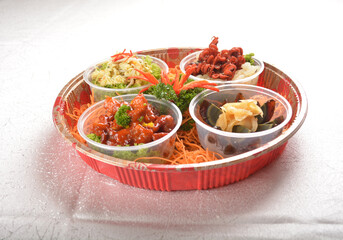 cold combo salad platter with sweet and sour pork, stir fried scrambler egg, preserved century egg with ginger and Japanese red marinated octopus in round party bento tray box for asian take away hala