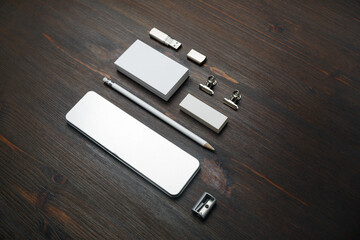 Photo of blank stationery set. Blank business card, pencil case, flash drive, pencil, eraser and sharpener on wooden background.