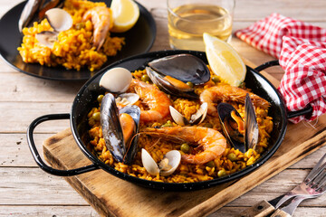 Traditional spanish seafood paella on wooden table - obrazy, fototapety, plakaty
