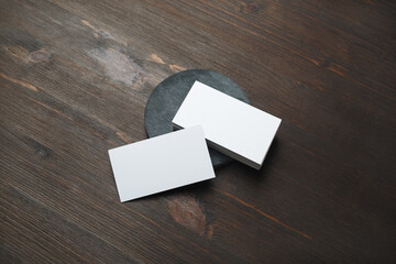 Blank white business cards on wood table background. Mockup for branding identity. Template for...