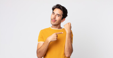 hispanic handsome man looking impatient and angry, pointing at watch, asking for punctuality, wants...