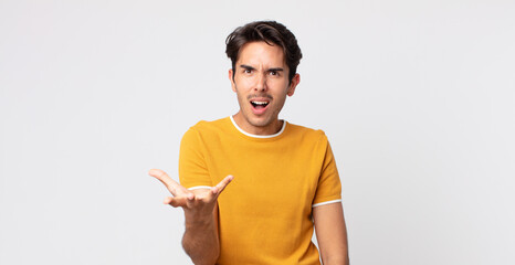 hispanic handsome man looking angry, annoyed and frustrated screaming wtf or what’s wrong with you