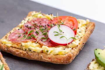 Sandwiches with cream cheese, vegetables and salami.