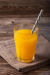 Glass with orange juice on the table.