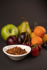 Fresh fruits and dried fruit powder. Pear, apple, apricot, cherry, currant, strawberry and plum on dark paper background. Vegetarian healthy detox food.