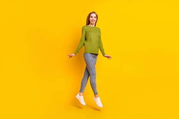 Full body photo of impressed orange hair young lady jump wear green sweater jeans isolated on yellow background