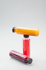 Plastic bottles of cold-pressed unprocessed fruit and vegetable juices, light gray table. Body cleanse, fast concept. Minimalist food photography. Copy Space. High quality photo