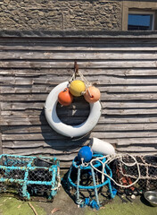Crab and lobster traps, lifebuoy and buoys on wooden wall