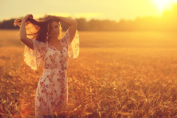 young brunette in summer with long hair in a field, happy person health beauty posing at sunset